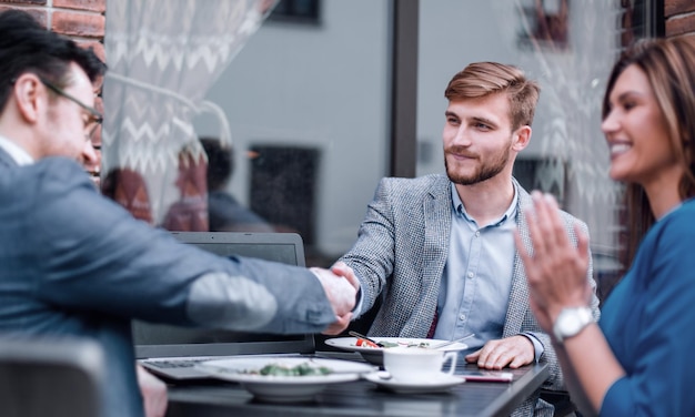 Os parceiros de negócios se cumprimentam no café