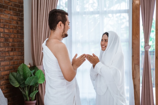 Os pares asiáticos do hajj muçulmano agitam as mãos