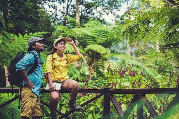 Os pares asiáticos viajam a natureza que relaxa e estuda a natureza nos fores.