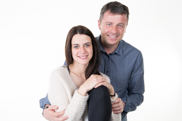 Os pares felizes novos bonitos amam sorrir abraçando o sorriso do homem e da mulher isolado no branco