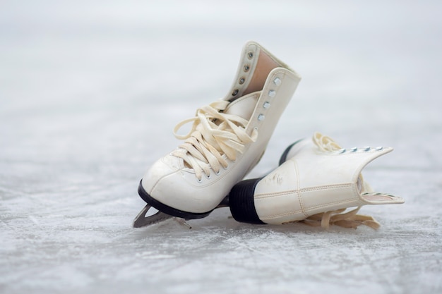 Os patins brancos encontram-se em uma pista de gelo aberta