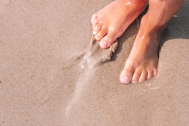 Os pés da menina na areia