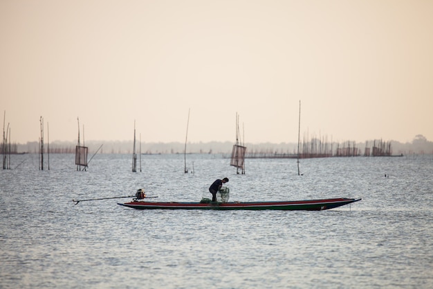 Os pescadores estão pescando no lago.