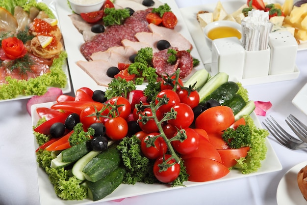 Os pratos abundantes na mesa de jantar, ao lado das iguarias da carne estão a salga do peixe e o prato com legumes.