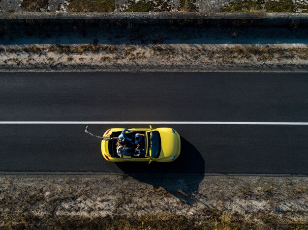 Os quatro amigos viajando de cabriolet amarelo