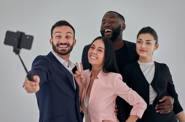 Os quatro empresários felizes fazendo selfie