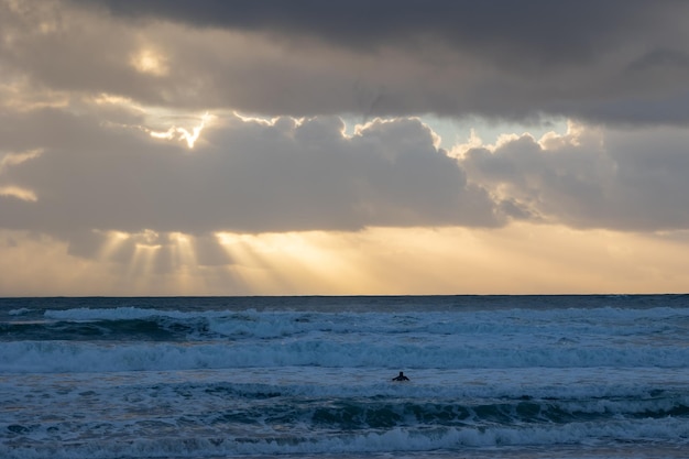 Os raios do sol rompem as nuvens sobre o mar azul