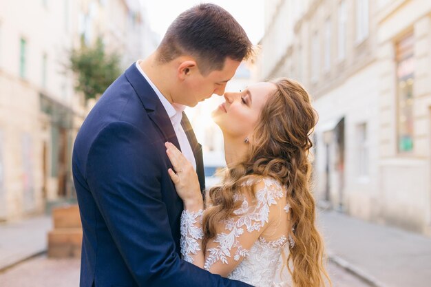 Os recém-casados fecharam os olhos e abraçaram-se na rua da cidade.