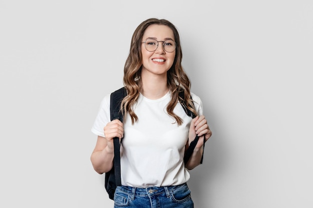 Os sorrisos da menina do estudante isolados sobre o fundo branco aprendem o conceito inglês