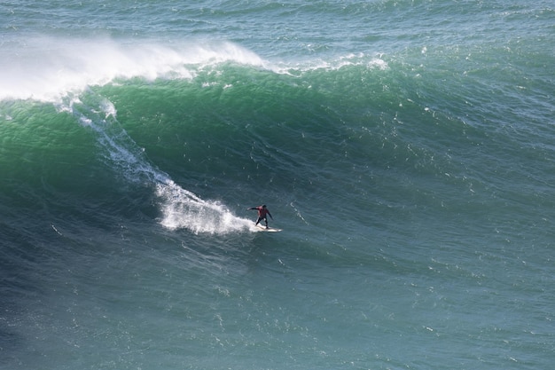 Os surfistas surfam nas grandes ondas do mar