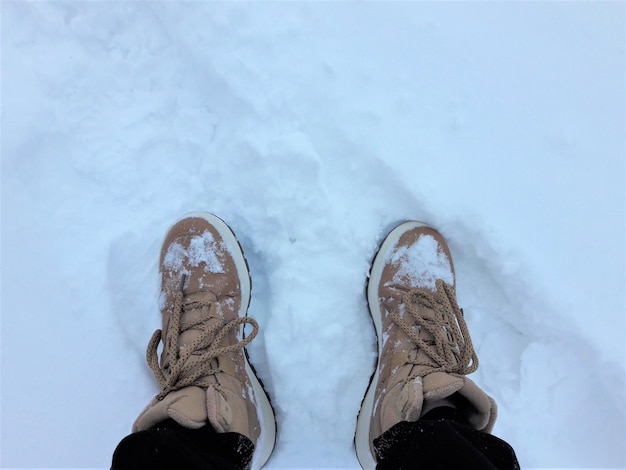 Os tênis de inverno. Botas no inverno em montes de neve. Caminhando no inverno nos pés de neve pov.