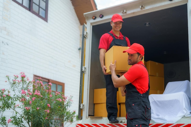 Os trabalhadores estão descarregando coisas de um caminhão para se mudarem para uma nova casa.