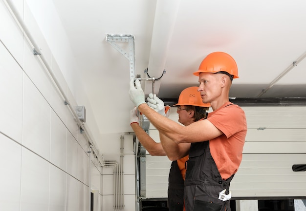 Os trabalhadores estão instalando portões de elevador na garagem.