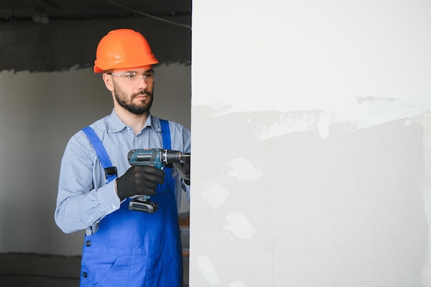 Os trabalhadores instalam uma parede de gesso cartonado