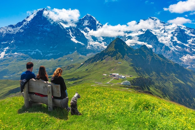 Os turistas admiram as montanhas Eiger, Monch e Jungfrau do cume da montanha Mannlichen, popular ponto de vista nos Alpes suíços, Suíça.