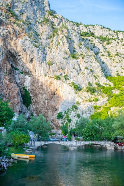 Os turistas da BÓSNIA E HERZEGOVINA BLAGAJ visitam a caverna de água das atrações locais na rocha