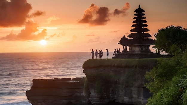 Os turistas ficam ao pôr-do-sol e admiram a paisagem em um penhasco perto do templo de uluwatu, na ilha de