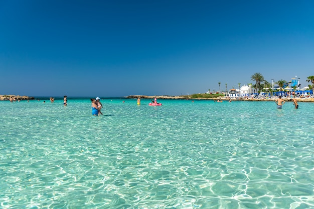 Foto os turistas relaxam e nadam em uma das praias mais populares da ilha.