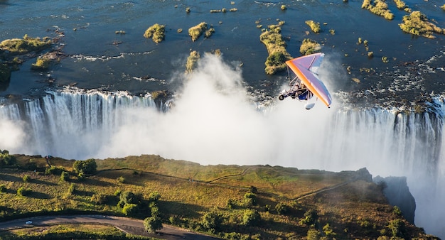 Os turistas sobrevoam as cataratas vitória de triciclo. áfrica. zâmbia. cataratas vitória.