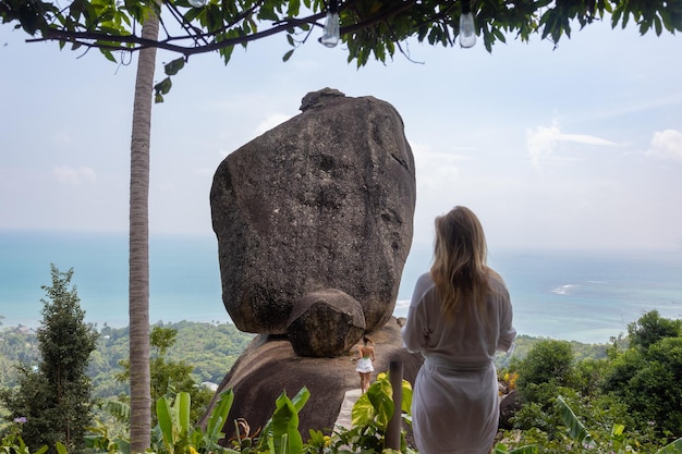 Os turistas tiram fotos na popular atração turística Overlap Stone com a pedra gigante Samui Tailândia
