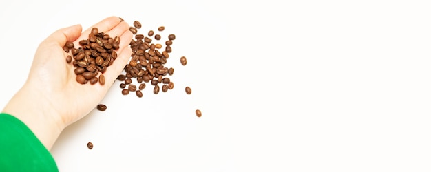 Oscuros granos de café tostados en la mano del agricultor con vista macro.
