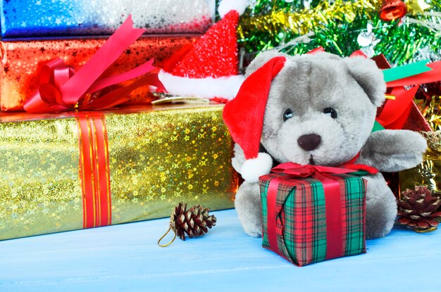 Foto osito de peluche con decoraciones de navidad y regalos en el suelo