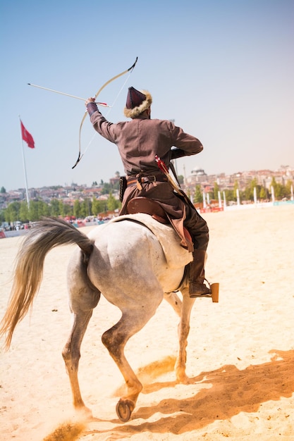 Foto osmanischer bogenschütze reitet und schießt zu pferd