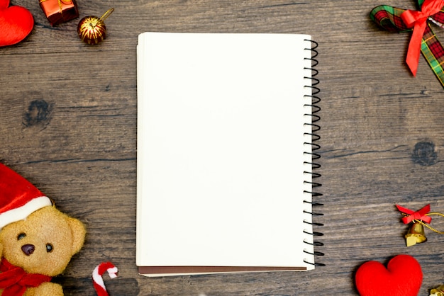 Foto oso de la navidad y libro en blanco con la vista superior y copyspace en la tabla de madera marrón. fondo de concepto de festival de navidad