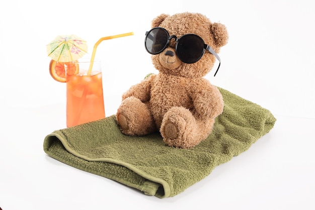 Un oso pardo de juguete disfruta de unas vacaciones con gafas de sol.