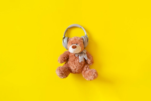 Oso de peluche en auriculares escuchar la radio de música de audio