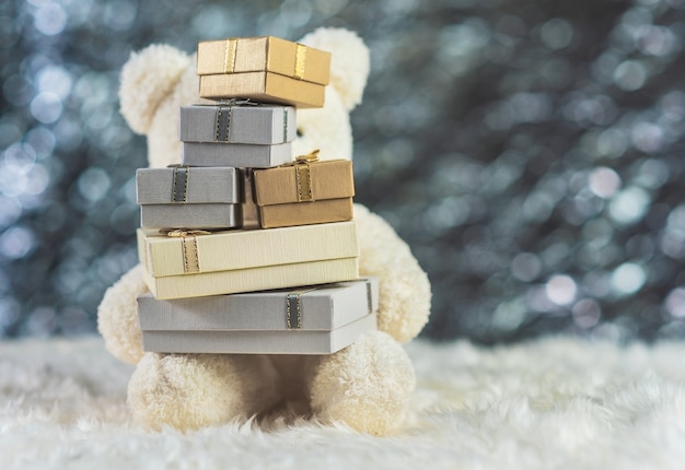 Oso de peluche blanco con cajas de regalo en lana