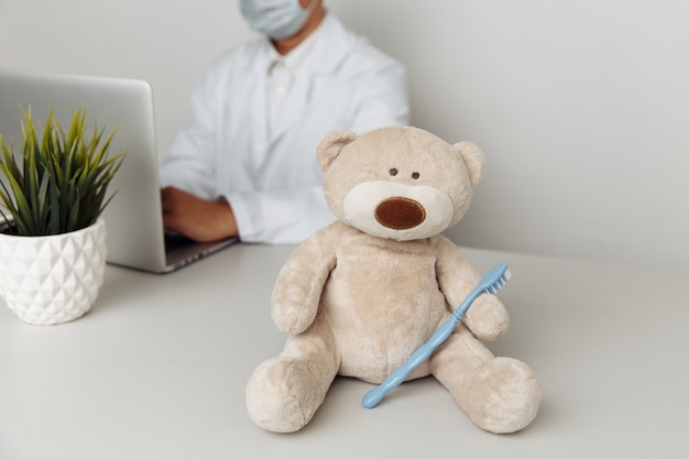 Foto oso de peluche con cepillo de dientes en la oficina de dentistas concepto de salud infantil