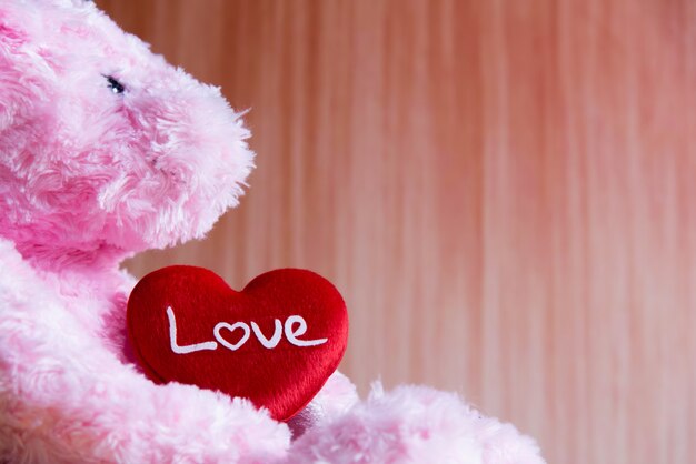 Foto oso de peluche con corazón sobre fondo de madera, san valentín