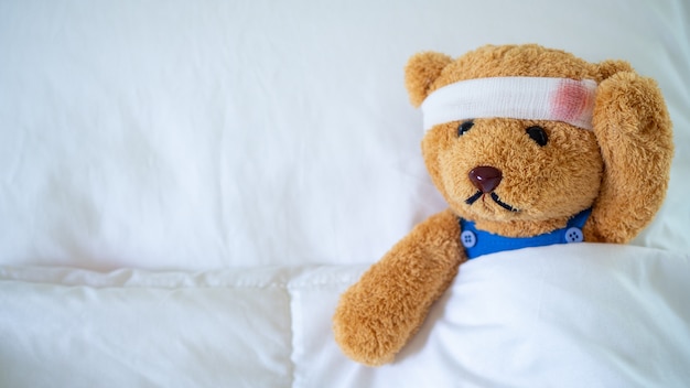 El oso de peluche estaba enfermo en la cama después de ser herido en un accidente.