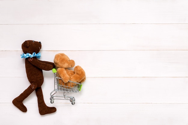 Oso de peluche con un oso en manos sobre fondo blanco.