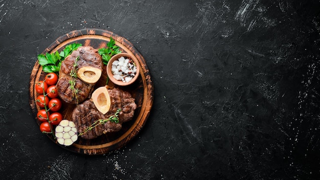 Osso buco cocido pierna de ternera sobre un fondo negro Vista superior Espacio libre para el texto