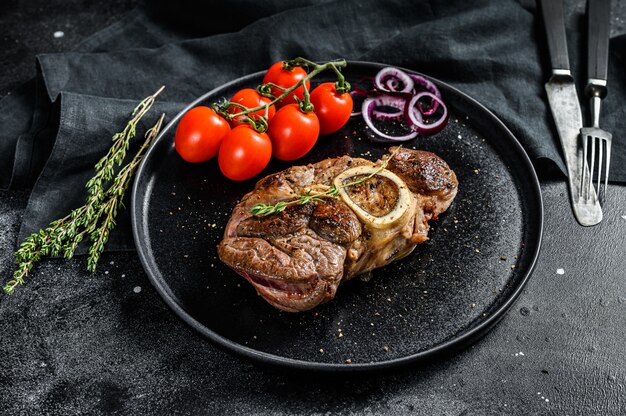 Osso Buco Fleisch mit Tomaten auf einem Teller