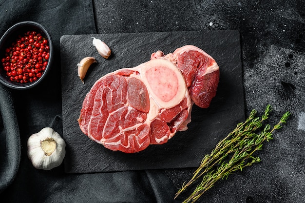 Ossobuco de carne cruda en una mesa con especias. Vista superior