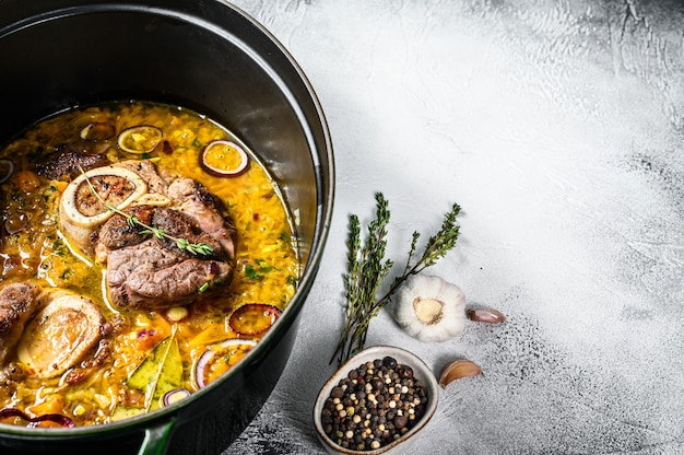 Ossobuco ensopado de carne com legumes. osso buco. fundo cinza.