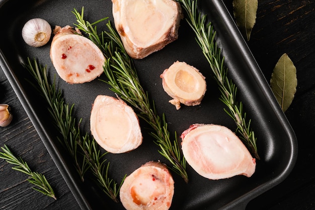 Ossos de carne para fazer caldo no fundo da mesa de madeira preta