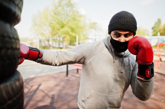 Ostenta o homem árabe do pugilista dos esportes no encaixotamento médico preto da máscara protetora exterior durante a quarentena do coronavírus.