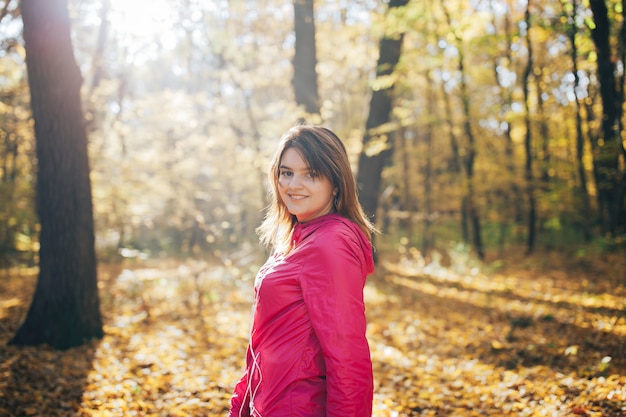 Ostenta trens da mulher na floresta do outono da manhã