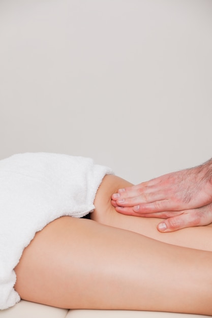 Osteopata massageando uma mulher na coxa