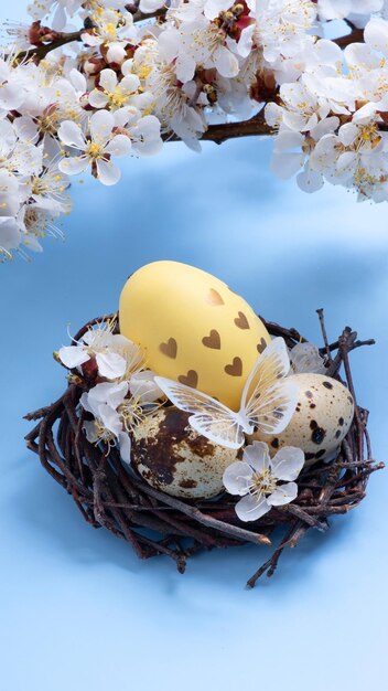 Oster-Eggs im Nest mit Blumen und Schmetterlingen auf blauem Hintergrund.