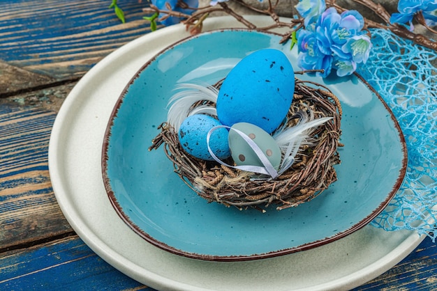 Foto oster-tischgestaltung mit eiern, vogel-nest und blühendem zweig