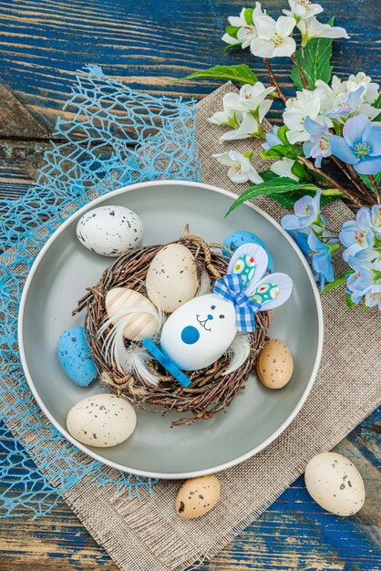 Foto oster-tischgestaltung mit eiern, vogel-nest und blühendem zweig