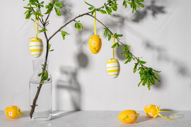 Osterbaum mit bunten Ostereiern gegen graue Wand