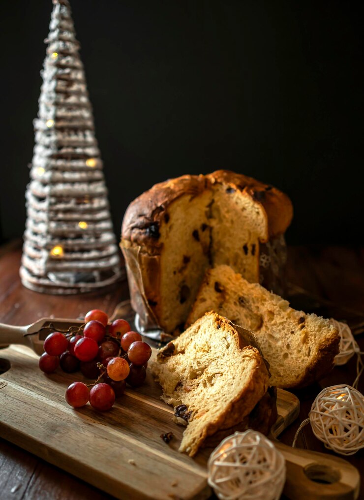 Osterbrot Weihnachten Panettone mit Trauben und Weißtanne mit Weihnachtsbeleuchtung Kopieren Sie Platz