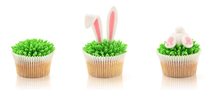 Ostercupcakes lokalisiert auf Weiß. Gras, Hasenarsch und Ohren.
