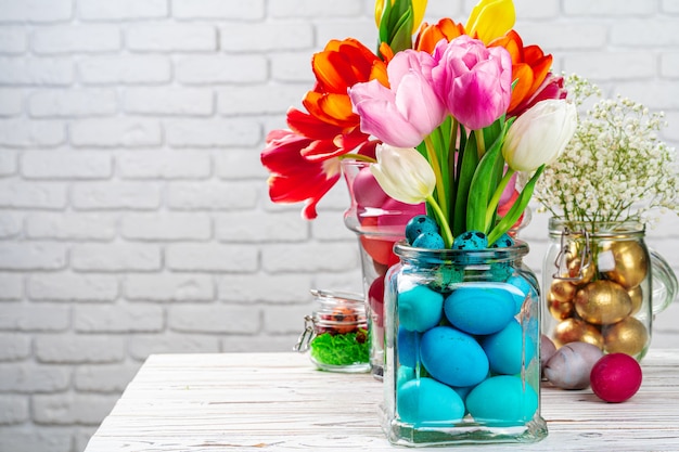 Osterdekoration. Blumenstrauß mit bunten Eiern